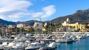 A marina with numerous boats docked, buildings in the background, and mountains in the distance. - [Authentic Caruggio] Typical Ligurian Experience (Loano)