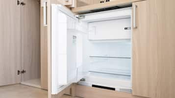Eine moderne Küche mit Einbaukühlschrank, Holzschränken und einer Edelstahl-Spüle.