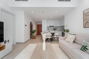 A modern apartment with a dining area, kitchen, and living room. - Gala Guests - Marina Views Collection (Dubai)