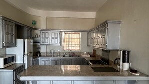 A kitchen with a central island, cabinets, a microwave, and a stove.