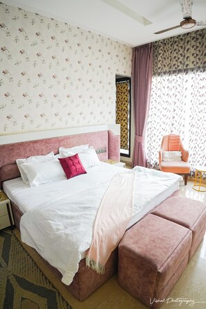 Ein Schlafzimmer mit einem Bett, einem Sessel und einem Fenster.