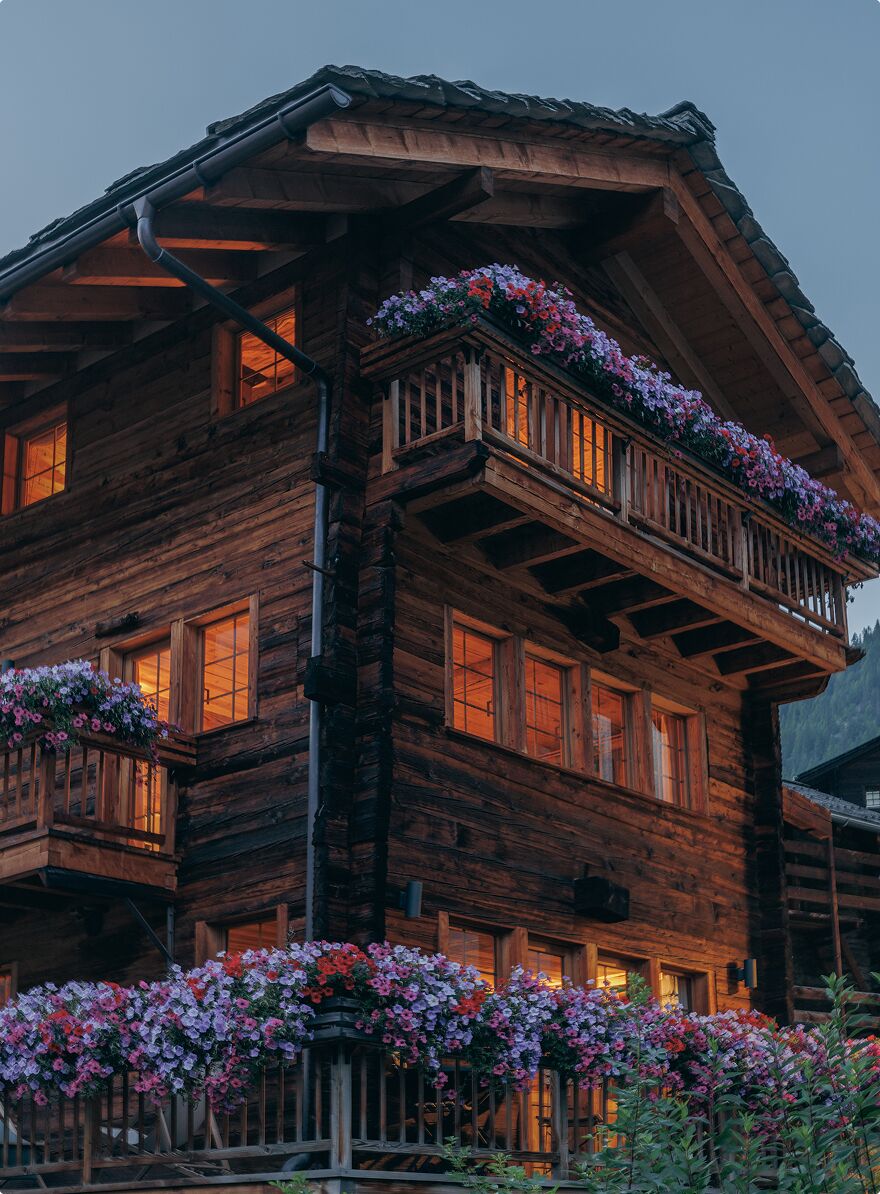 Un bâtiment en bois doté de nombreux balcons, chacun étant agrémenté de jardinières fleuries.