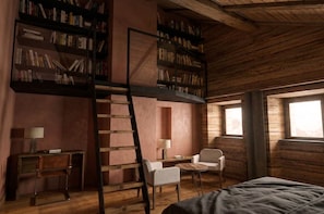 Ein Schlafzimmer im Loft-Stil mit Schlafgalerie, einer Leiter, einem Schreibtisch, zwei Stühlen und Bücherregalen.