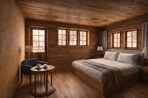 Una habitación tipo cabaña de madera con cama, dos ventanas, una silla, una mesita y una lámpara.
