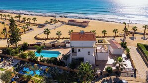 Une propriété située en bord de mer, dotée d’une piscine, d’une plage et offrant une vue sur l’océan.