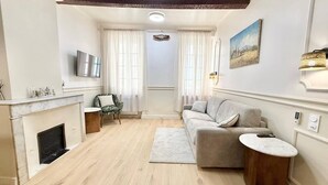 Een woonkamer met een open haard, een bank, een salontafel en een televisie.
