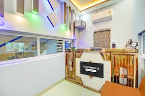 Ein Empfangsschalter mit einem Schild, das 'TOWNHOUSE Company-Serviced' zeigt, eine Treppe und ein Fenster mit Blick.