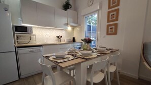 Una cucina moderna con pensili bianchi, un forno a microonde e un tavolo da pranzo per quattro persone.