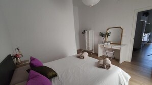 Una camera da letto con un letto, una scrivania, uno specchio e un armadio.