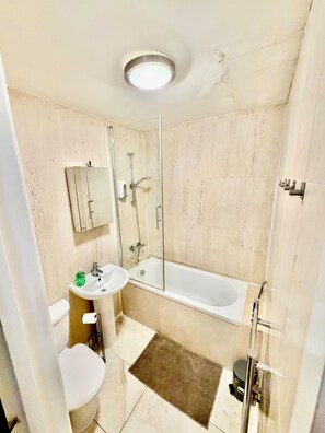 A bathroom with a toilet, sink, and bathtub. - 1 Bedroom Flat Cambridge City Centre Location (Cambridge)