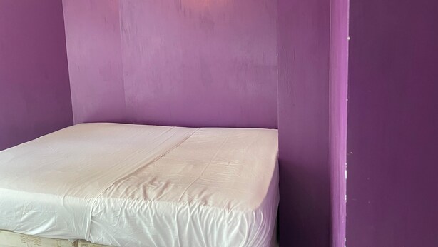 A room with a single bed, purple walls, and a visible door frame. - Privet bedroom in share home (London)