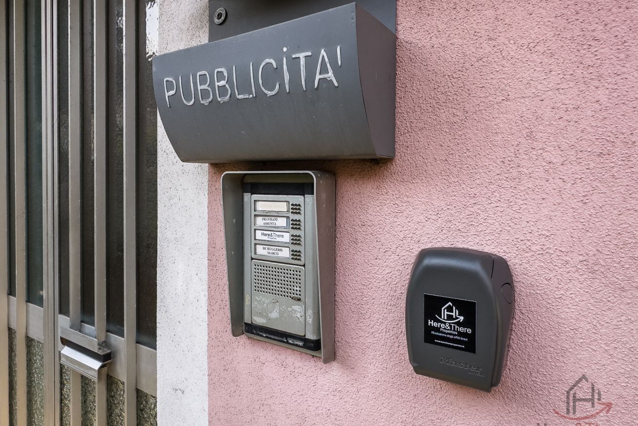 A public telephone booth with a sign above it and a keypad below.