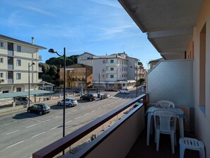 Ein Balkon mit Blick auf eine Straße, Autos und Gebäude.