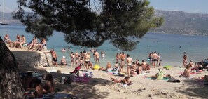 Ein Strand mit badenden und sonnenden Personen.