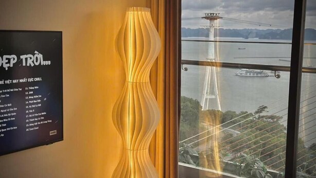 A room with a view of a bridge and water, a decorative lamp, and a menu board. - Jade Leaves Homestay HaLong -Seaview (Hong Gai)