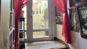 Una escalera con cortinas rojas, una puerta que da al exterior y vistas al exterior.