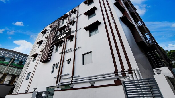 A multi-story building with a white facade, multiple windows, and a sign indicating 'Downtown House Oak.'