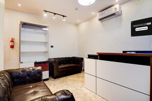 Quarto com sofá de couro, um armário branco, um extintor de incêndio e uma placa com a inscrição 'TOWNHOUSE OAK Company-Serviced'.