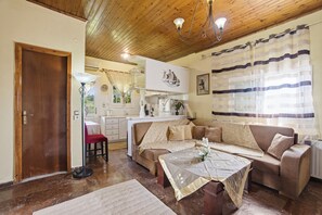 A cozy living room with a sofa, a coffee table, and a dining area. - Flat near Corfu Airport with Balcony, Wi-Fi, and Air Conditioning (Kastania)