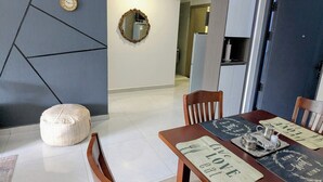 Moderni ruokailutila, jossa on puinen pöytä, tuolit ja seinällä koristeellinen peili.