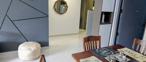 A modern dining area with a wooden table, chairs, and a decorative mirror on the wall.