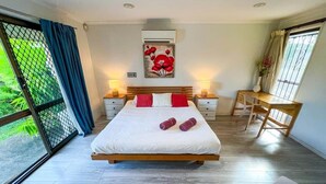 A bedroom with a bed, bedside tables, a desk, and a chair. - Bonhaven Deluxe King Room with private Bathroom (Runcorn)