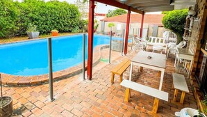 A covered patio with a pool, outdoor furniture, and a brick floor. - Bonhaven Deluxe King Room with private Bathroom (Runcorn)
