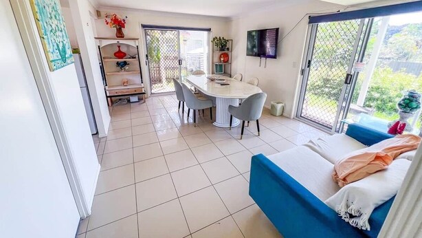 A modern room with a dining area, a sofa, and a TV. - Unique Japanese Ensuite Room futon tatami 3 people (Runcorn)