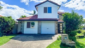 A two-story house with a garage, a gravel driveway, and a small brick structure in front. - Unique Japanese Ensuite Room futon tatami 3 people (Runcorn)