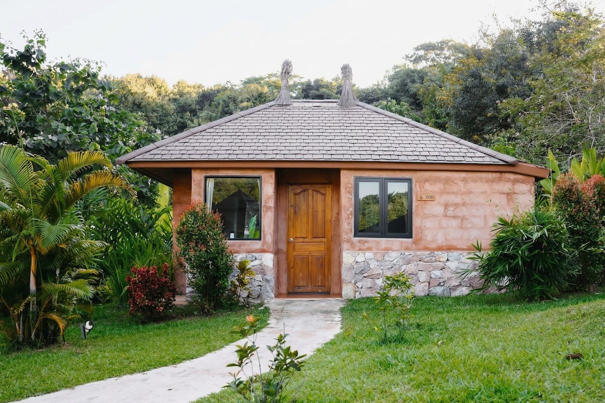 A small house with a stone facade, a wooden door, and a tiled roof.