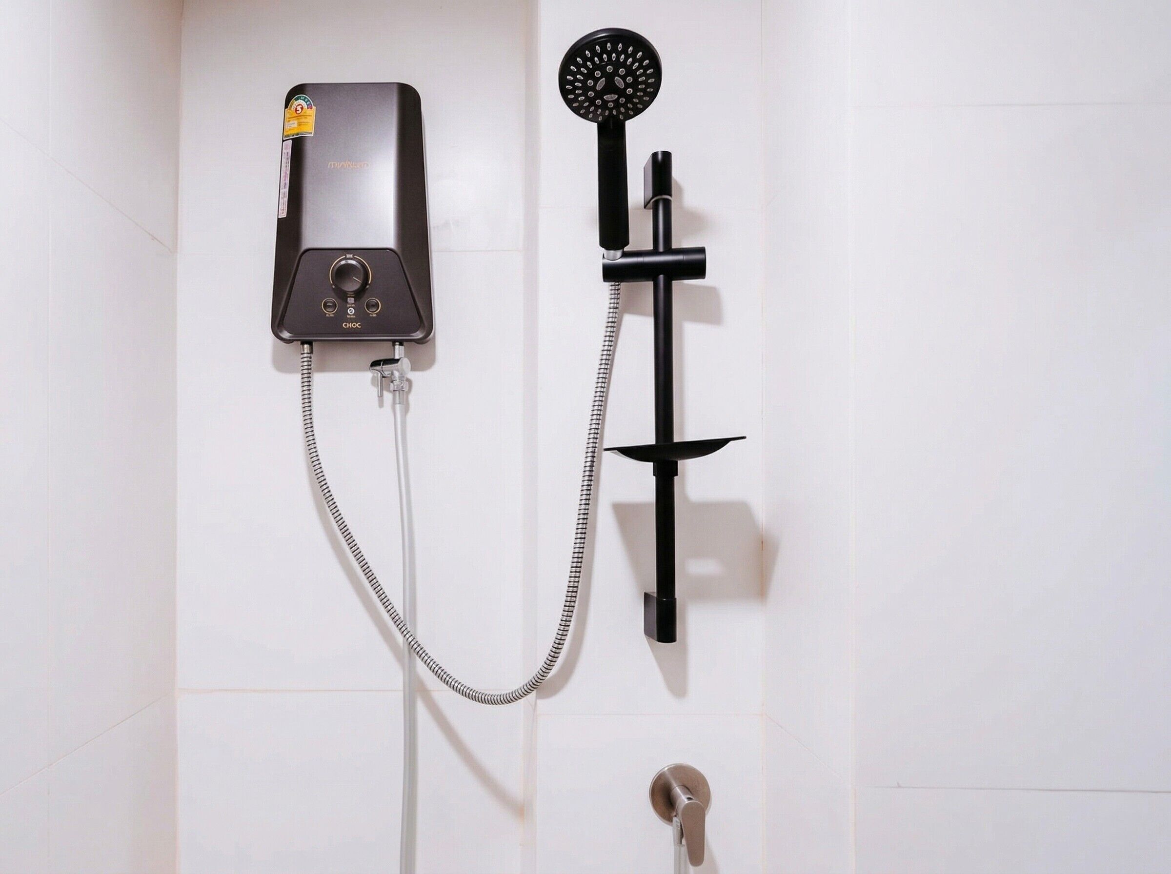 Un ensemble de douche mural comprenant une douchette à main et un panneau de commande.