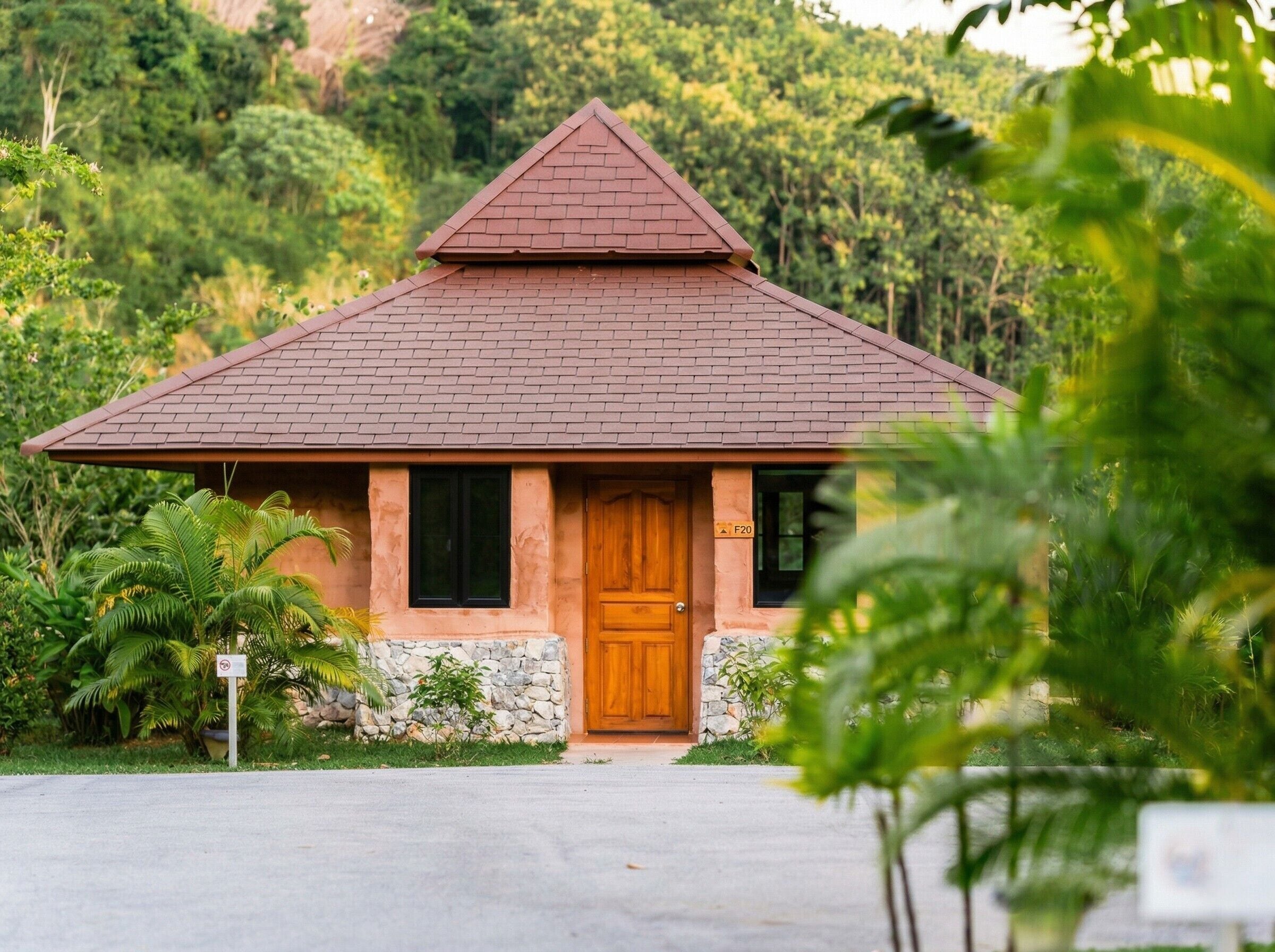 A small house with a brick roof, a wooden door, and a stone wall base.