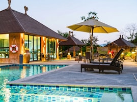 Una piscina al aire libre, sombrillas, tumbonas