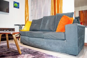 A living room with a sofa, a small table, and a television on the wall. - Beautiful studio in Nairobi perfect for your city getaway.
5 minutes from CBD (Nairobi)