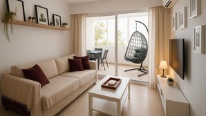 Ein modernes Wohnzimmer mit Sofa, Hängekorbschaukel, Fernseher und Essbereich mit Tisch und Stühlen.