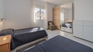 A modern bedroom with two beds, a small seating area, and a large mirror. - Villa in Marbella near the beach, private pool, 4 bedrooms, 3 bathrooms, sleeps 10 (Marbella)
