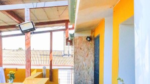 A covered outdoor area with a tiled floor, a bench, a potted plant, and a wall-mounted sign. - Blue Nest Ottava - A few minutes from Sassari (Ottava)