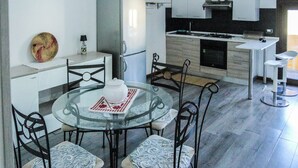 A compact kitchen with a refrigerator, stove, and white cabinets. - Blue Nest Ottava - A few minutes from Sassari (Ottava)