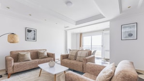 A modern living room with two sofas, a coffee table, and a large window.