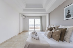 A hotel room with a bed, pillows, a towel, a framed picture, and a view through a door. - Spacieux appartement de 3 pieces (Algiers)