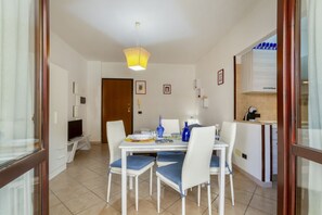 A dining area with a table, chairs, a television, and a kitchen area. - A cozy studio apartment that comfortably accommodates two people, equipped with every comfort for a pleasant stay, including a furnished balcony for relaxing. The apartment is located in a quiet area, well-equipped with essential amenities, just a 10-min (Lecce)