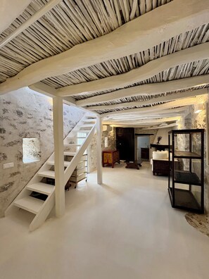 A spacious interior with a white staircase, a wooden cabinet, and a glass display unit. - Siena House Hydra - Renovated in 2026 (Idra)