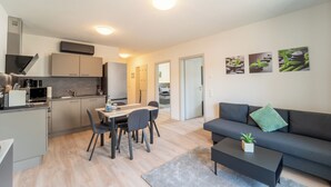 Ein modernes Apartment mit Küche, Essbereich und Wohnzimmer.