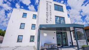 Ein modernes, zweistöckiges Gebäude mit der Beschilderung 'Neckartal Aparthotel', das als Hotel gekennzeichnet ist.
