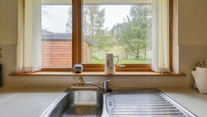 Una cucina con una finestra, un lavello e un bancone in legno.