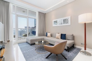 A modern living room with a sectional sofa, a round coffee table, and a floor lamp. - Gala Guests - Maison Prive Collection (Dubai)
