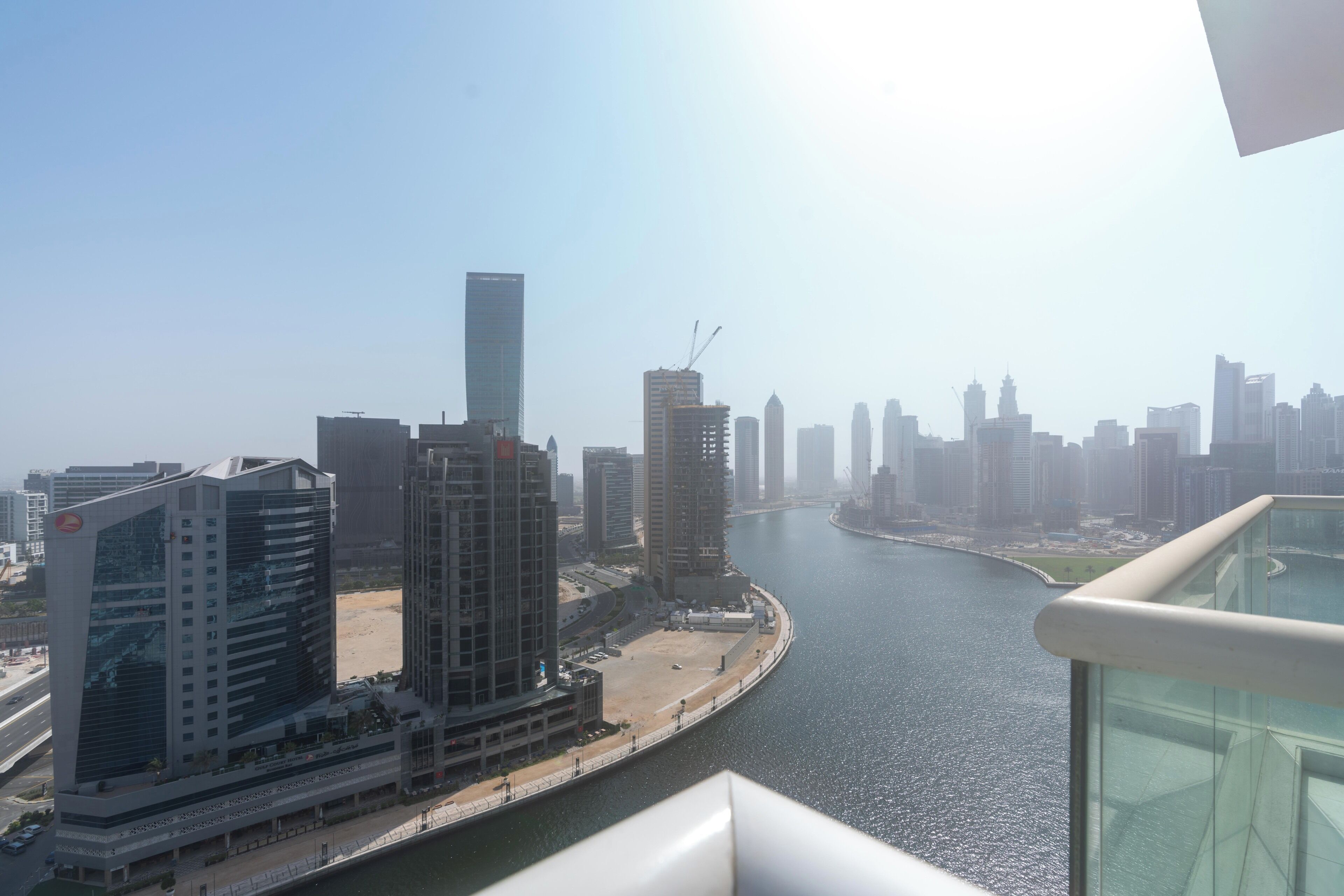 A high-rise building with a river in the background, modern architecture, and a clear sky.