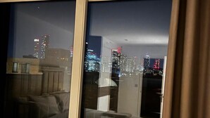 Una habitación con vista a un horizonte urbano nocturno.