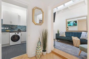 Ein kompakter Wohnbereich mit einer Küche, einem Sofa und einem Fernseher.