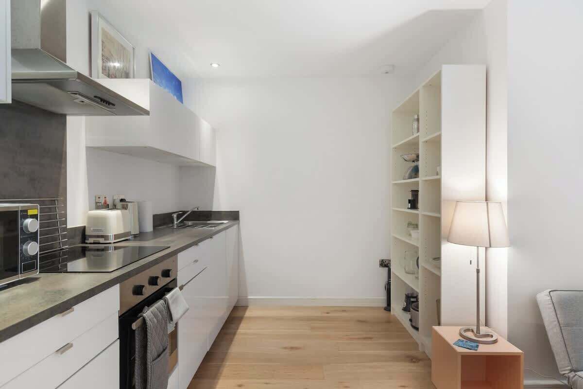A compact kitchen with modern appliances, a built-in oven, and a microwave.